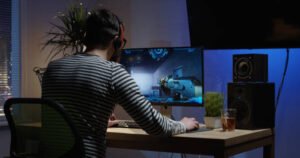Medium shot of a young man playing shooting video game inside a room
